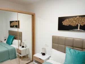 a bedroom with a mirror and a bed with blue pillows at El Rincon de Riera in Pola de Lena