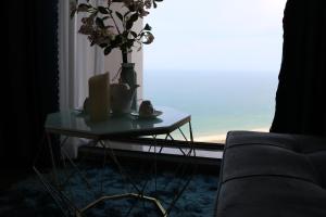 a living room with a table with a vase of flowers on it at Apec Mui Ne Chill Sea View in Ấp Thiẹn Ái