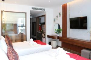 a living room with two beds and a television at Apec Mui Ne Chill Sea View in Ấp Thiẹn Ái