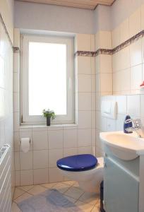ein Badezimmer mit Toilette und Waschbecken und einem Fenster in der Unterkunft Komfortable Ferienwohnung in Bockhorn mit Großem Balkon - b48718 in Walsrode