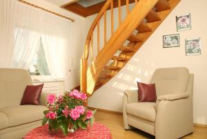 ein Wohnzimmer mit 2 Stühlen und einer Treppe in der Unterkunft Komfortable Ferienwohnung in Bockhorn mit Großem Balkon - b48718 in Walsrode