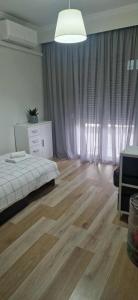 Schlafzimmer mit einem Bett, einer Kommode und Vorhängen in der Unterkunft Comfort apartment in Veria