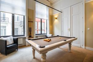 a room with a pool table and a chair at Hotel Made In Louise in Brussels