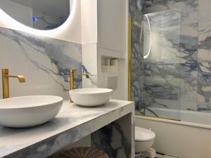La salle de bains est pourvue de 2 lavabos et d'un comptoir en marbre. dans l'établissement Bezons Golden - 3 chambres - 3min du Tramway #SirDest, à Bezons