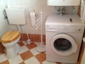 ein Badezimmer mit Waschmaschine und Toilette in der Unterkunft Ferienhaus in luftiger Höhenlage mit tollem Ausblick von der Terrasse auf den See im Tal in Sankt Urban