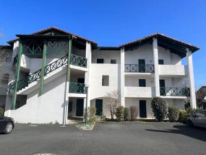 a large white apartment building with a parking lot at Studio Églantine à Cambo-les-Bains, proche thermes, terrasse, parking, accès Internet, animaux OK - FR-1-495-106 in Cambo-les-Bains