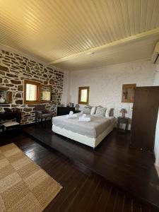 a bedroom with a bed and a stone wall at Castle Rizaraki in Kokkala