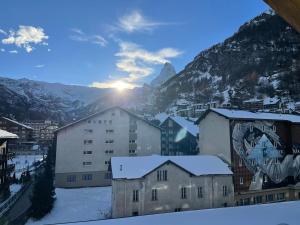 采尔马特Penthouse Matterhorn Vista的享有城市美景,拥有雪覆盖的建筑和山脉