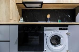 a kitchen with a washing machine under a counter at Zoris Apart1 in Bacău