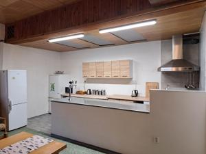 a large kitchen with white appliances and wooden ceilings at Chata JedlOvka in Jiřetín pod Jedlovou
