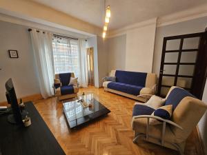 a living room with blue couches and a table at Union City Centre Apartament in Craiova