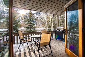a screened porch with a table and chairs and a grill at Sun Valley Condo 123 in Ketchum