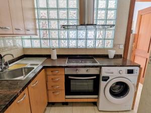 a kitchen with a stove and a washing machine at VV 68 Secretario Artiles in Las Palmas de Gran Canaria