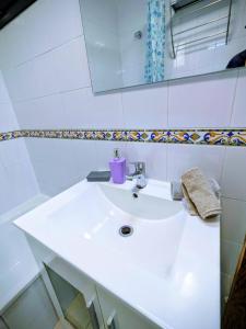 a bathroom with a white sink and a mirror at VV 68 Secretario Artiles in Las Palmas de Gran Canaria