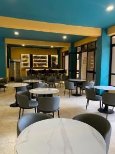 ein Esszimmer mit Tischen und Stühlen und einer blauen Wand in der Unterkunft Wyne's Hotel in Mbale