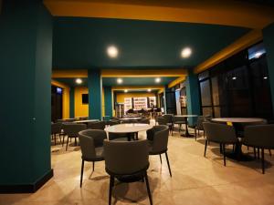 ein Restaurant mit Tischen und Stühlen und einer grünen Wand in der Unterkunft Wyne's Hotel in Mbale + 8 Fotos