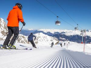 eine Gruppe von Menschen fährt mit Skiern einen schneebedeckten Berg hinunter in der Unterkunft Charmant 2.5 pièces à Courchevel Village - Près des pistes, pour 4 pers., label charme 9/10 - FR-1-575-67 in Courchevel + 3 Fotos