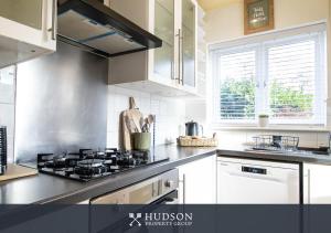 a kitchen with white cabinets and a stove top oven at Home with Rear Terrace in Ironbridge in Ironbridge