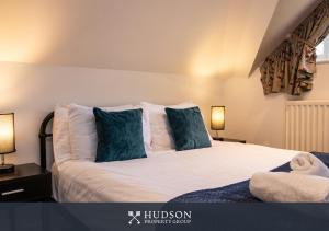 a bedroom with a large white bed with blue pillows at Home with Rear Terrace in Ironbridge in Ironbridge