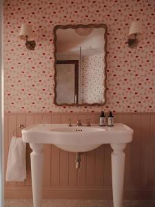 ein Badezimmer mit einem weißen Waschbecken und einem Spiegel in der Unterkunft Luxury Apartment with Roof Terrace - Cotswolds in Stow on the Wold