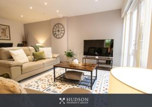 a living room with a couch and a tv at Home with Rear Terrace in Ironbridge in Ironbridge