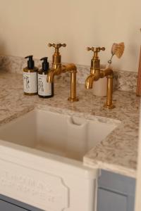 eine Küchenarbeitsplatte mit goldenen Armaturen und einem Waschbecken in der Unterkunft Luxury Apartment with Roof Terrace - Cotswolds in Stow on the Wold + 10 Fotos