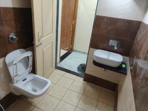 a bathroom with a toilet and a sink at Vasant Vihar Farm House in Silvassa
