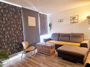 ein Wohnzimmer mit Sofa und Tisch in der Unterkunft Le DrômArdèchois - Gîte meublé Ardèche - WIFI Parking - Écolodgîte Drôme ardèche in Tournon-sur-Rhône