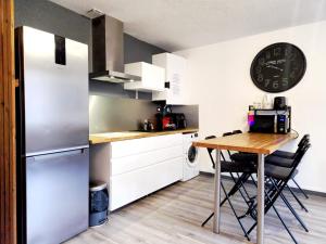 eine Küche mit einem Tisch und einer Uhr an der Wand in der Unterkunft Le DrômArdèchois - Gîte meublé Ardèche - WIFI Parking - Écolodgîte Drôme ardèche in Tournon-sur-Rhône + 33 Fotos