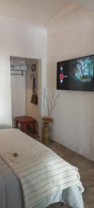 a bedroom with a bed and a flat screen tv on the wall at Casita de Norma, Mercedes Corrientes!!! in Mercedes