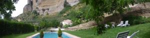 a swimming pool in a field with a mountain in the background at Huerta del Tajo in Ronda