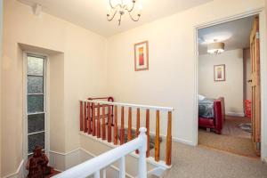 a staircase in a home with a chandelier at The Old Bakehouse - Group Getaway in Llandysul +68 photos