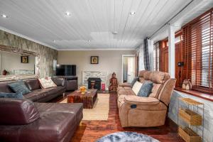 een woonkamer met lederen meubels en een open haard bij The Old Bakehouse - Group Getaway in Llandysul +67 foto's