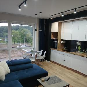 a living room with a blue couch and a table at Apartament u Andrzeja in Mrągowo