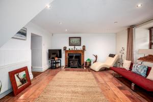 a living room with a red couch and a fireplace at Historic 4BR Home - The Old Bakehouse in Llandysul