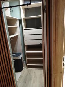a closet with white drawers and a door open at Apartament u Andrzeja in Mrągowo