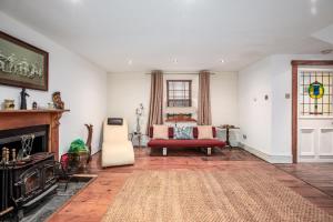 a living room with a couch and a fireplace at Historic 4BR Home - The Old Bakehouse in Llandysul