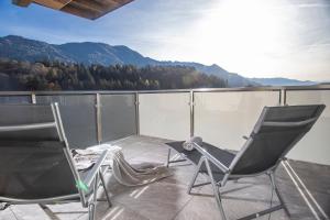 维辛Apart Dahoam的两把椅子坐在一个山景阳台上,背景是