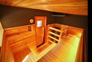 a room with a sauna with wooden walls and wooden floors at Hotel&Sauna Osakaya in Kaizuka
