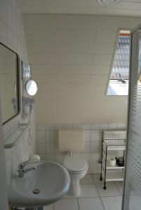 un bagno bianco con lavandino e WC di Fewo Stricker 13 a Walkenried