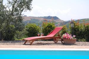 une chaise rouge assise à côté d'un pot de fleurs dans l'établissement Solaria Orvieto, à Orvieto