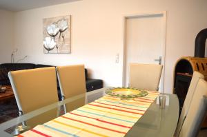a dining room with a glass table and chairs at Ferienhaus Meerzeit in Dornum