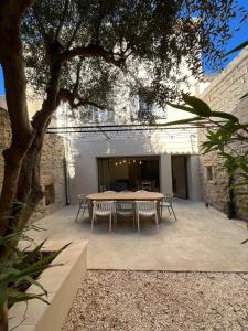 Chez Louise et Léo في إج مورت: طاولة وكراسي في ساحة مع شجرة
