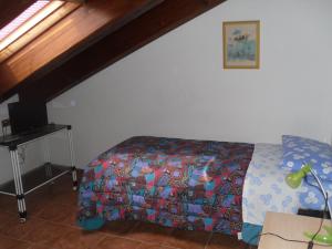 a bedroom with a bed with a colorful blanket at Agriturismo Le Giare in Genova