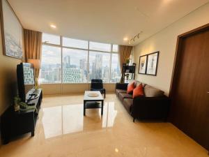 un salon avec un canapé et une grande fenêtre dans l'établissement VorteX KLCC By City Center, à Kuala Lumpur