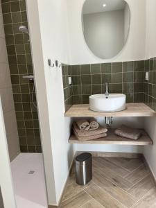 Chez Louise et Léo في إج مورت: حمام مزود بحوض ومِرآة