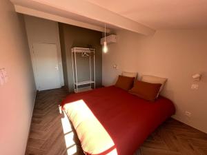 Chez Louise et Léo في إج مورت: غرفة نوم بسرير احمر كبير في غرفة