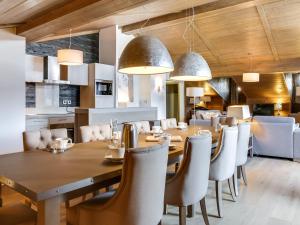 une salle à manger avec une grande table et des chaises en bois dans l'établissement Luxueux appartement 4 pièces au cœur de Courchevel Village, à proximité des pistes et commerces - FR-1-562-32, à Courchevel