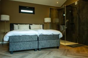 a bedroom with a large bed and a shower at Rijn Residentie in Alphen aan den Rijn