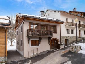 ein großes weißes Gebäude mit einem Balkon darauf in der Unterkunft Chalet chaleureux familial avec spa, sauna et proche pistes à Méribel Village. - FR-1-566-24 in Les Allues